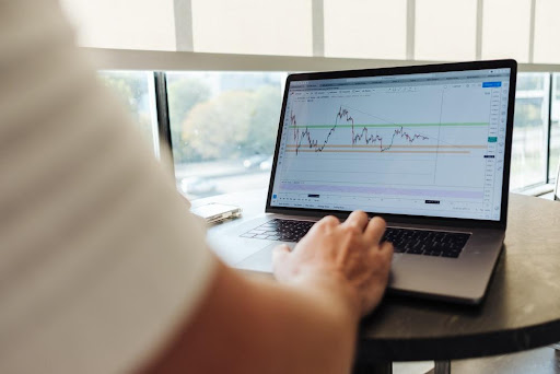 A Person Viewing A Market Graph On A Laptop Screen