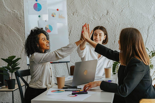 Women on a table giving high five